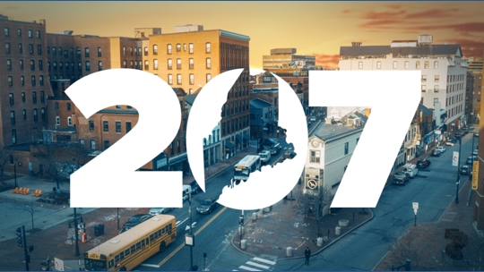 Text '207' over an arial view of Congress Square in Portland, Maine